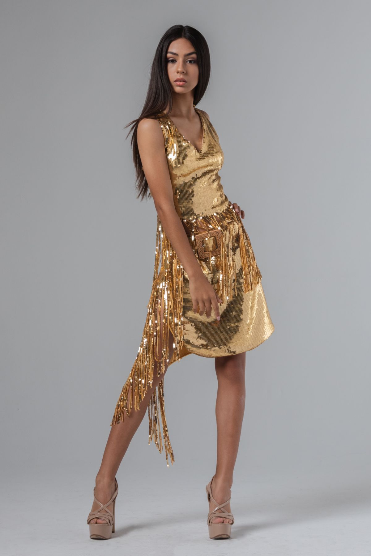 Brünettes Model in einem goldenen Paillettenkleid und hautfarbenen High Heels Sandaletten mit Plateausohlen